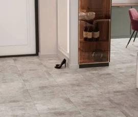 Grey, concrete-look SPC tile flooring in a modern interior with a display cabinet