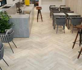 Light ash wood-look SPC flooring laid in a herringbone pattern in a modern café