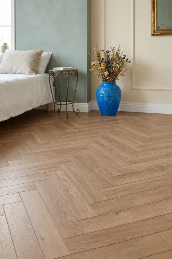 Light brown herringbone wood flooring in a bedroom