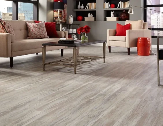Light weathered wood-look SPC flooring in a modern, furnished living room.