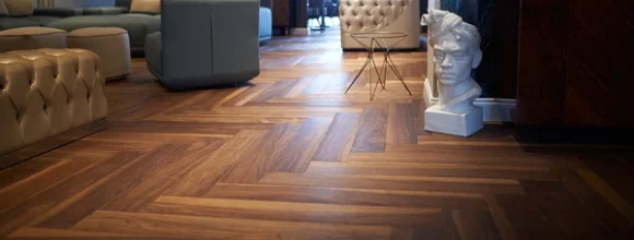 Rich brown wood flooring in a herringbone pattern in a modern living space.